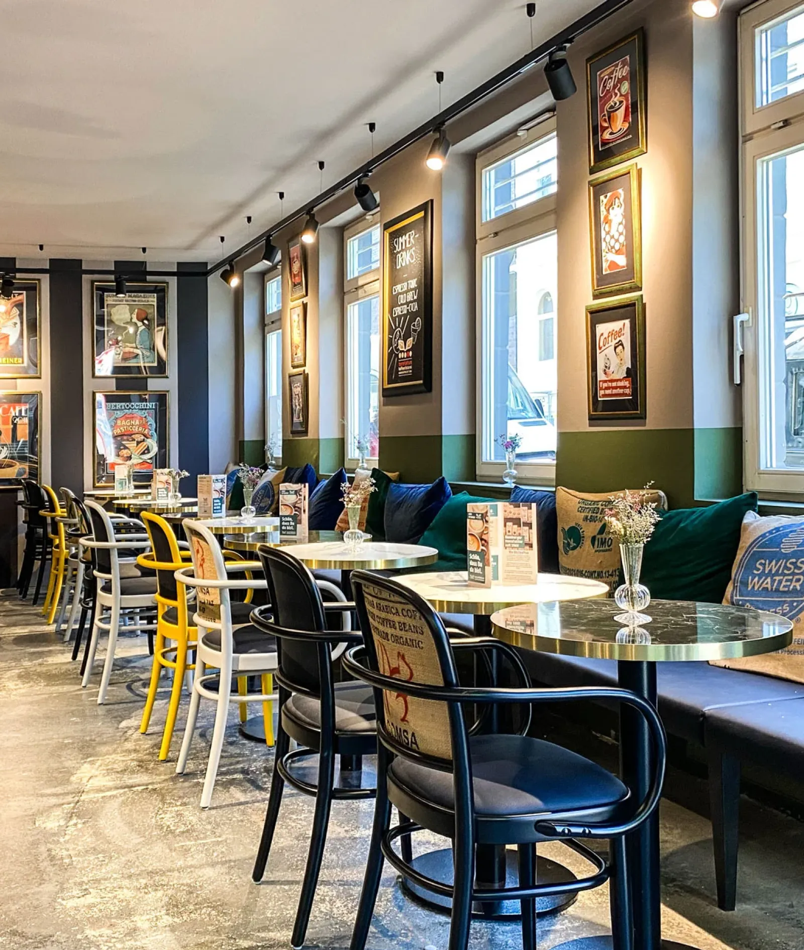 Das stilvolle Café Torrefaktum zeigt eine gemütliche Atmosphäre mit bunten Stühlen und handwerklicher Kaffeequalität.